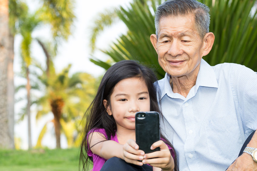 Grandfather and grandchild making selfie with smart phone in the park