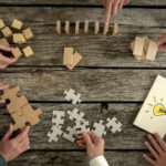 Business men using puzzle pieces to demonstrate teamwork