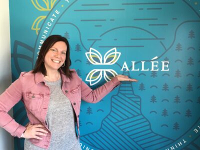 Woman standing in front of blue wall that says Allee